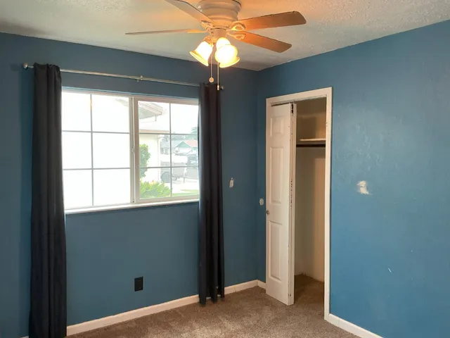 a view of a livingroom with a chandelier fan and a window