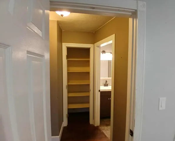 a view of a hallway with wooden shelves