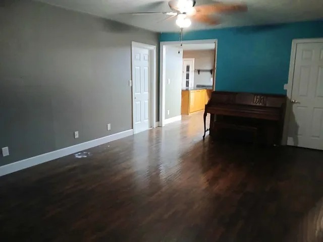 a view of a room with wooden floor and a window