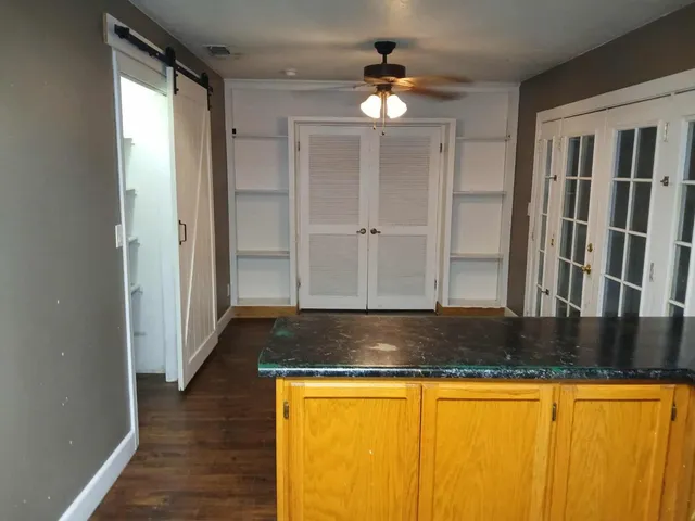 a view of granite countertop cabinets and wooden floor