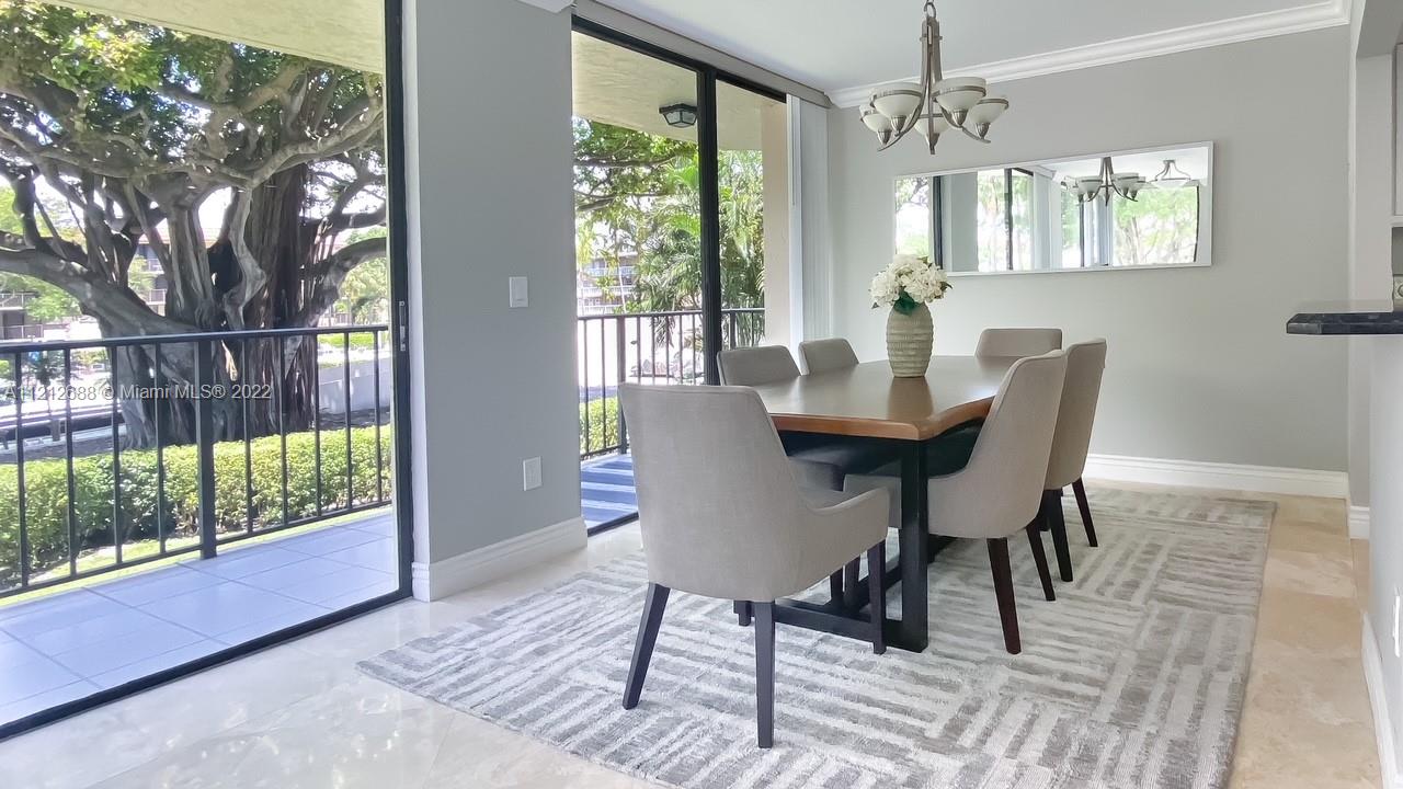 859 Jeffery Street, Unit 201 Boca Raton, FL 33487 - Photo 11 of 33 a view of a dining room with furniture wooden floor and a chandelier