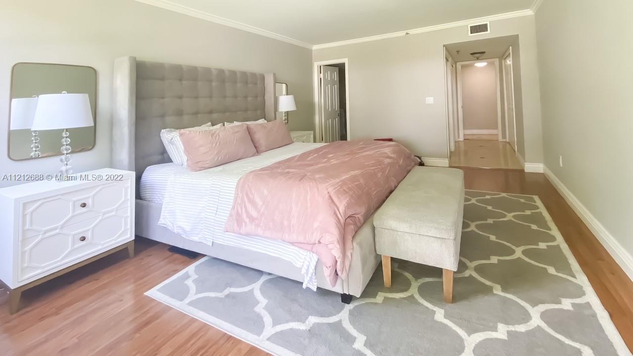 859 Jeffery Street, Unit 201 Boca Raton, FL 33487 - Photo 16 of 33 a bedroom with a bed and a mirror