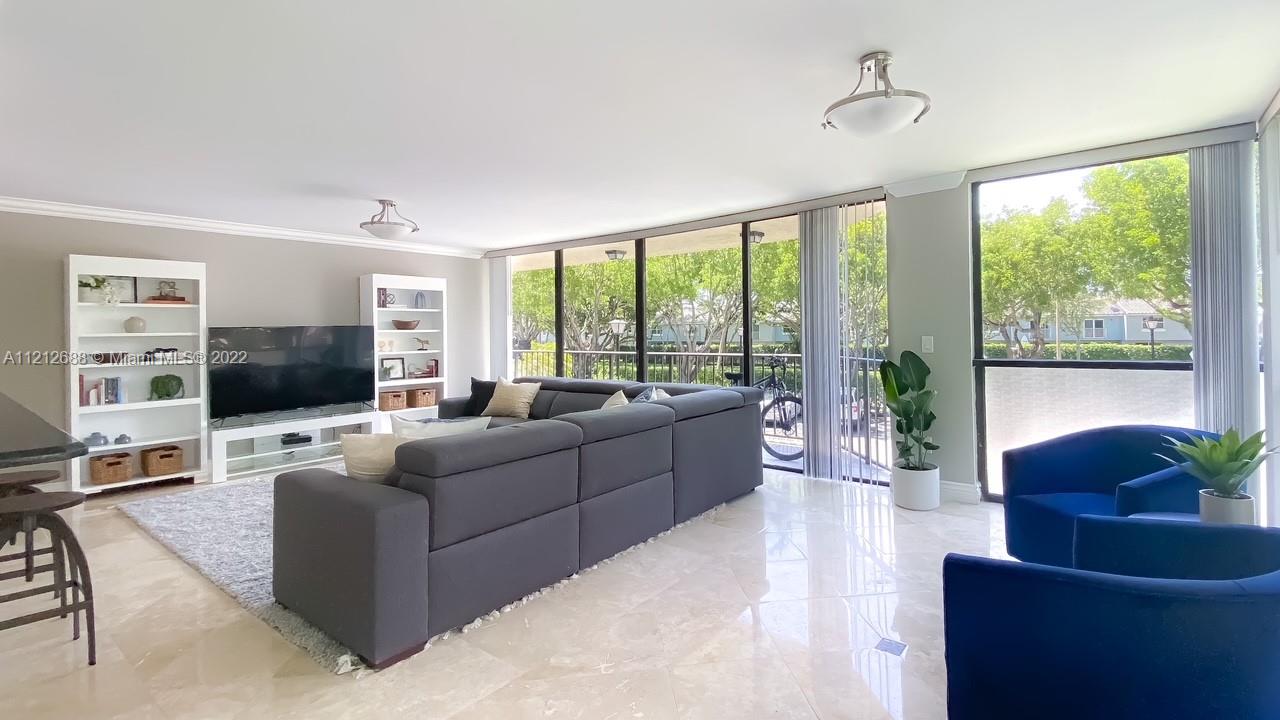 859 Jeffery Street, Unit 201 Boca Raton, FL 33487 - Photo 8 of 33 a living room with furniture large windows and a flat screen tv