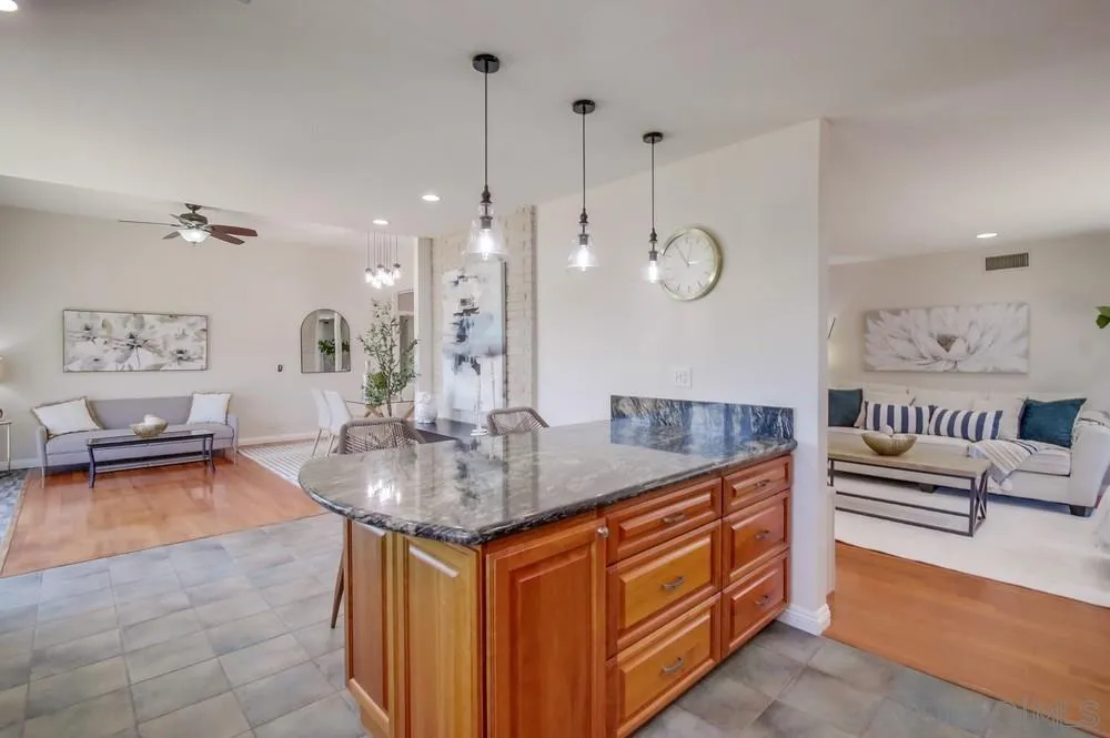 14747 Dash Way Poway, CA 92064 - Photo 18 of 65 a very nice looking room with kitchen island stainless steel appliances a couch and a chandelier