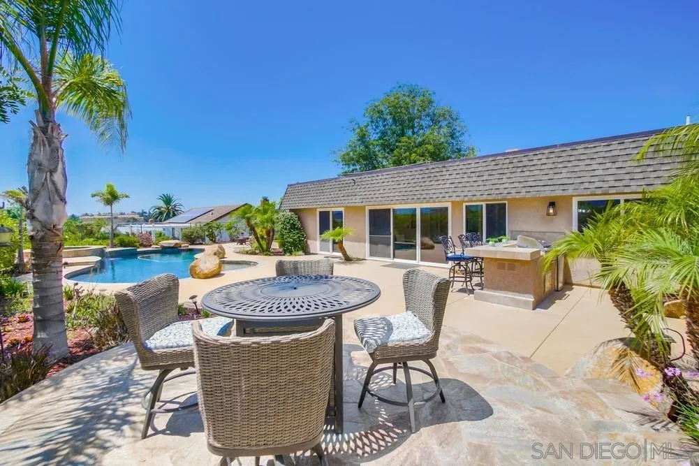 14747 Dash Way Poway, CA 92064 - Photo 32 of 65 a view of a patio with table and chairs potted plants and palm tree
