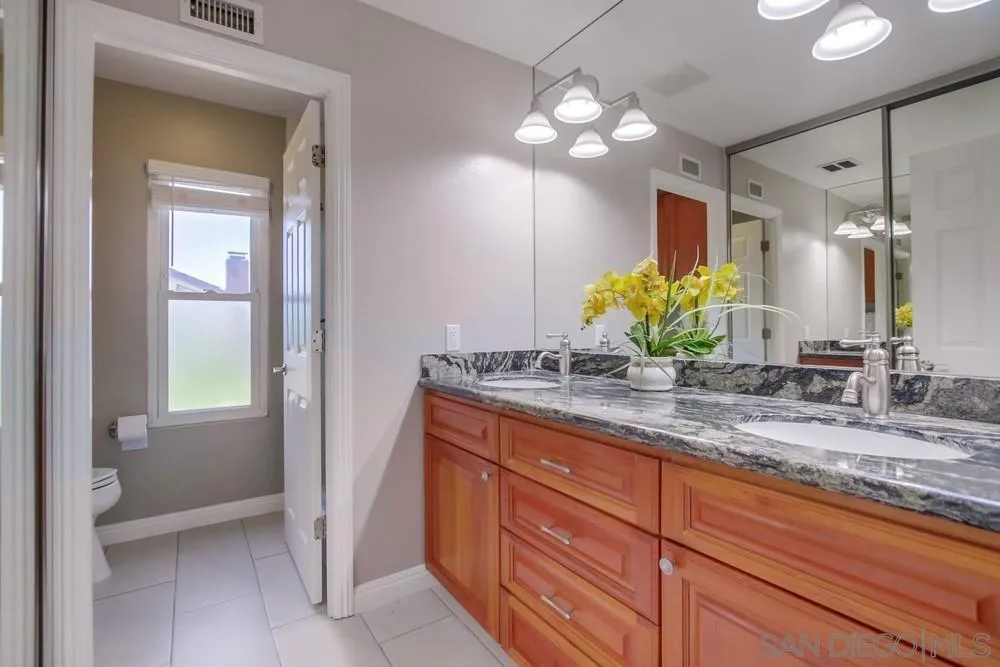 14747 Dash Way Poway, CA 92064 - Photo 49 of 65 a bathroom with a granite countertop sink and a mirror