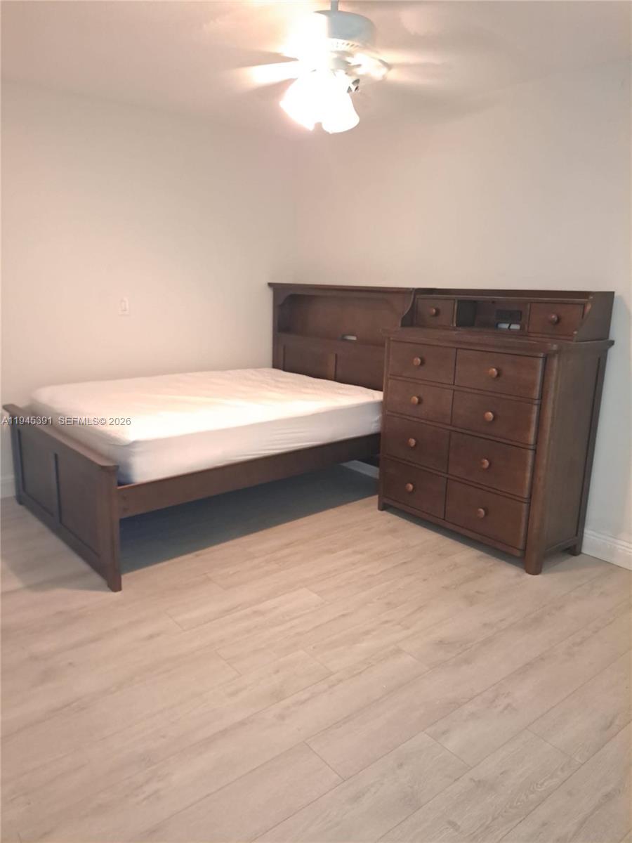 2220 North 57th Way, Unit 2 Hollywood, FL 33021 - Photo 3 of 4 a bedroom with a bed and a chandelier