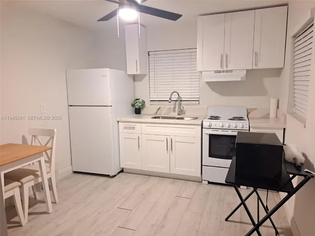a kitchen with a sink a stove a refrigerator and cabinets