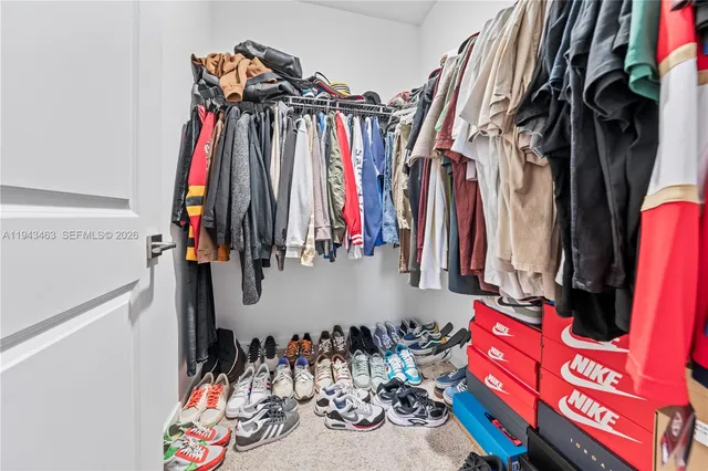 a view of walk in closet with clothes and shoes