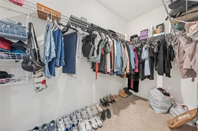a view of walk in closet with clothes and shoes