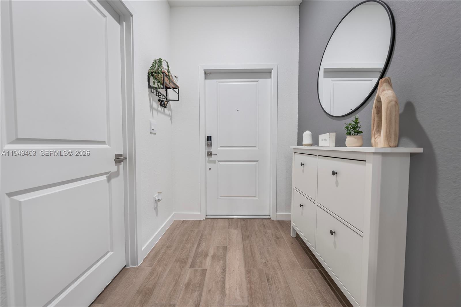 818 Southeast 17 Street, Unit 818 Homestead, FL 33034 - Photo 14 of 36 wooden floor in an entryway with a mirror