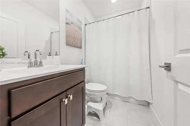 a bathroom with a sink a toilet and shower curtain
