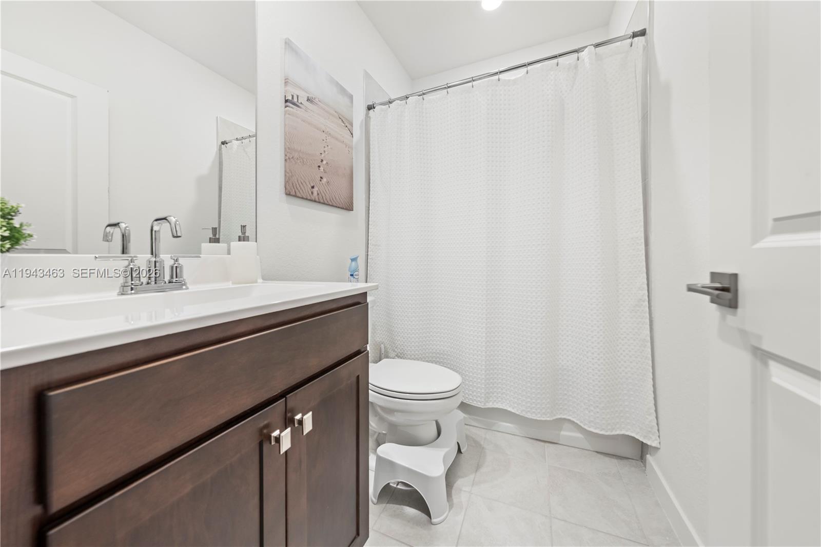 818 Southeast 17 Street, Unit 818 Homestead, FL 33034 - Photo 15 of 36 a bathroom with a sink a toilet and shower curtain