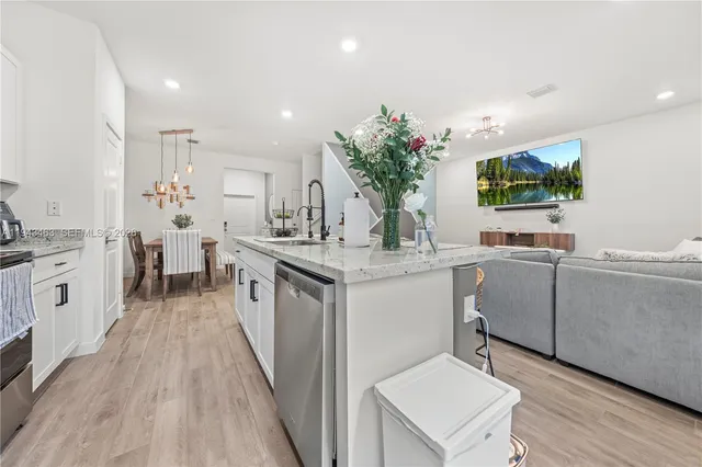 a kitchen with white cabinets and sink