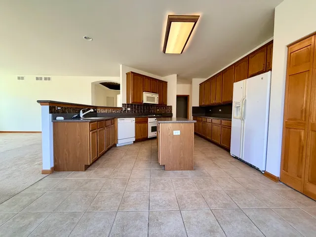 a kitchen with stainless steel appliances granite countertop a stove top oven and refrigerator