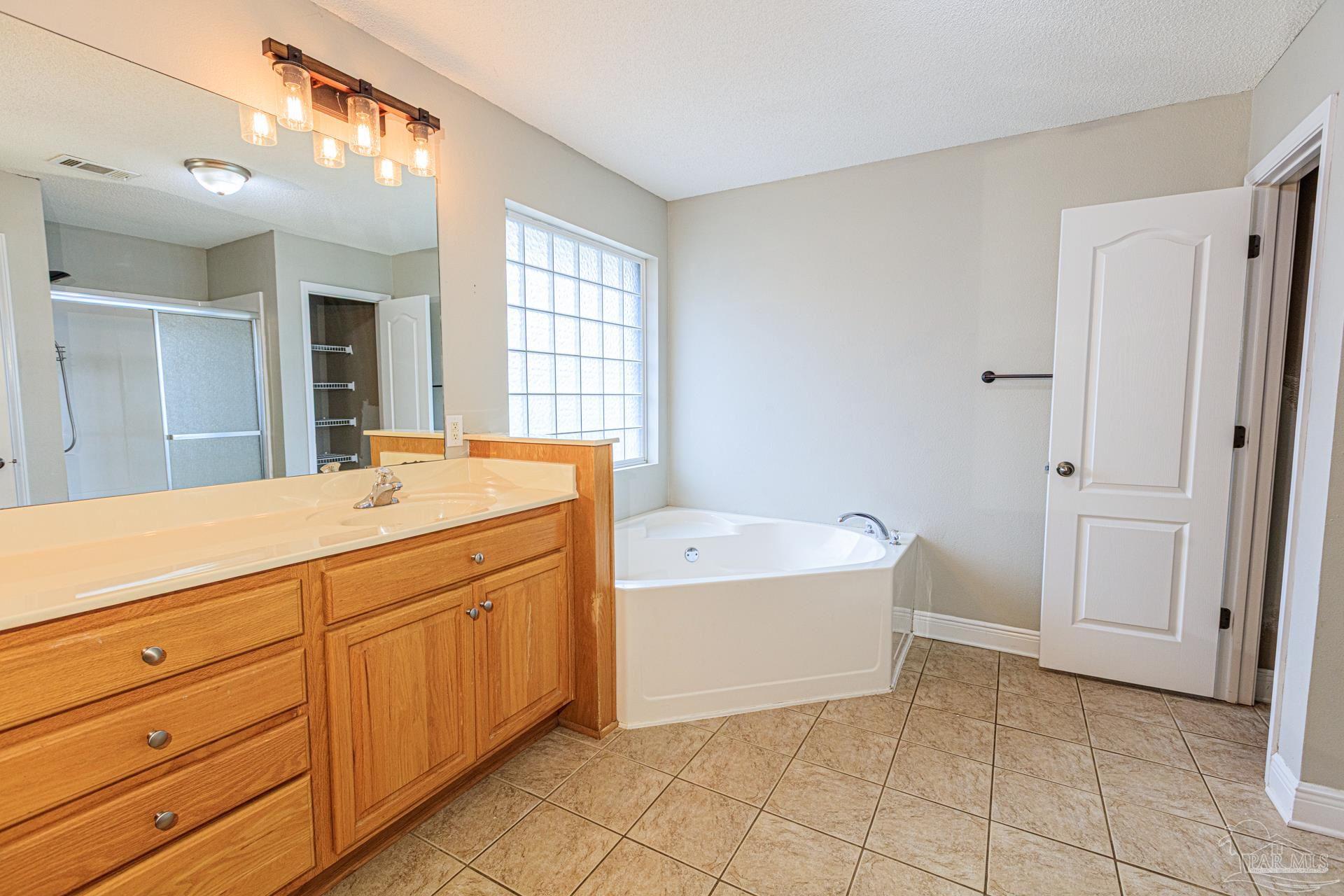 2863 Wallace Lake Road Pace, FL 32571 - Photo 15 of 44 a spacious bathroom with a tub sink and mirror