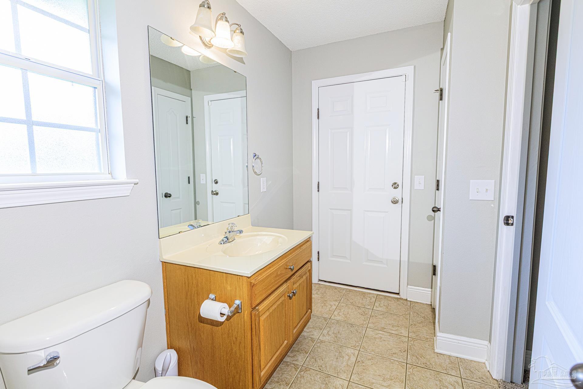 2863 Wallace Lake Road Pace, FL 32571 - Photo 25 of 44 a bathroom with a sink a toilet and a mirror