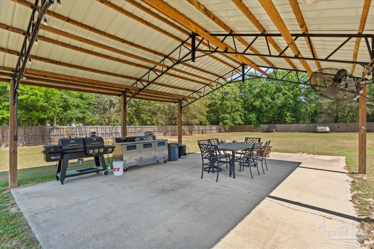 2863 Wallace Lake Road Pace, FL 32571 - Photo 39 of 44 a view of a patio with table and chairs and potted plants