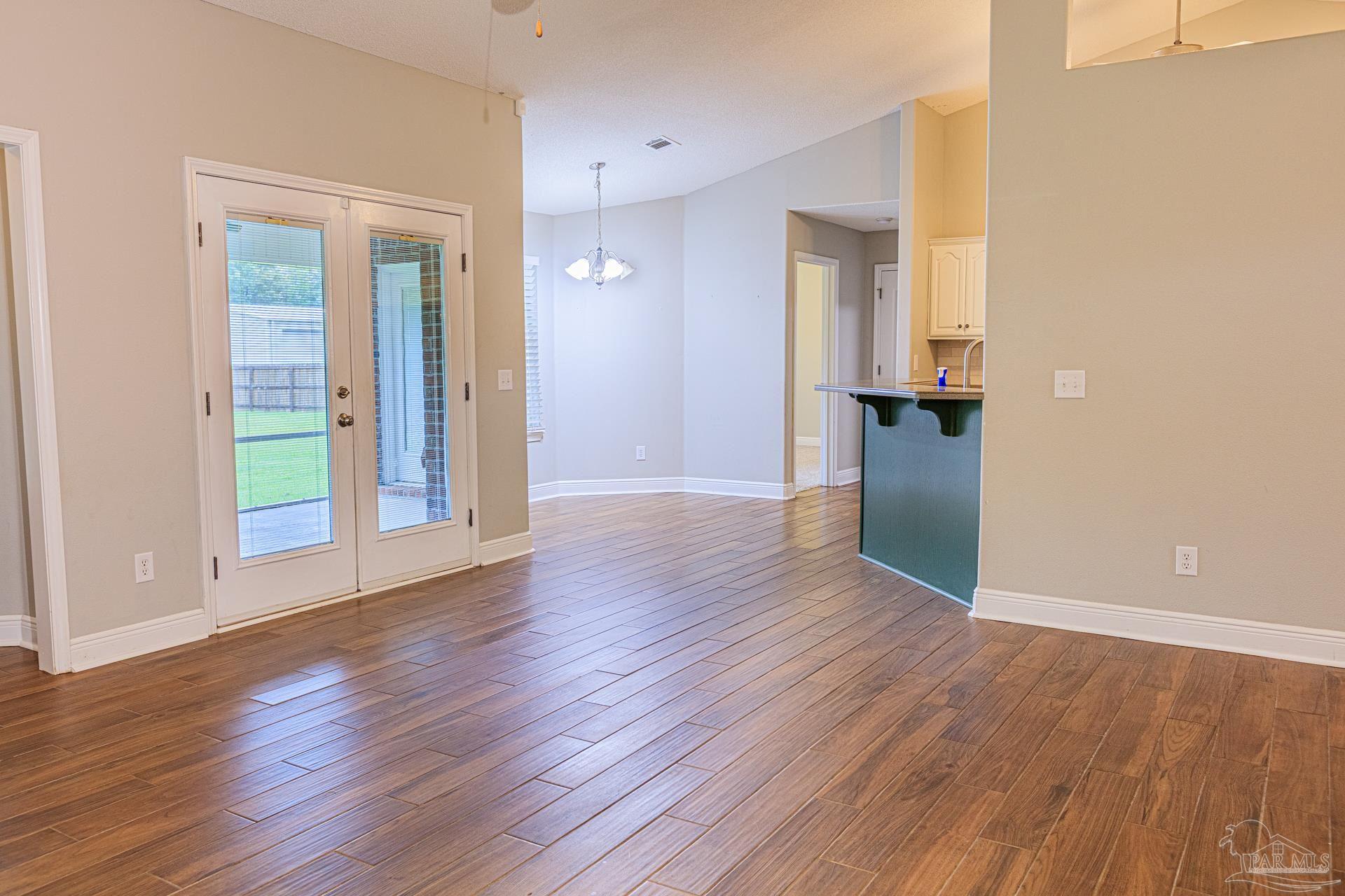 2863 Wallace Lake Road Pace, FL 32571 - Photo 7 of 44 an empty room with wooden floor & windows