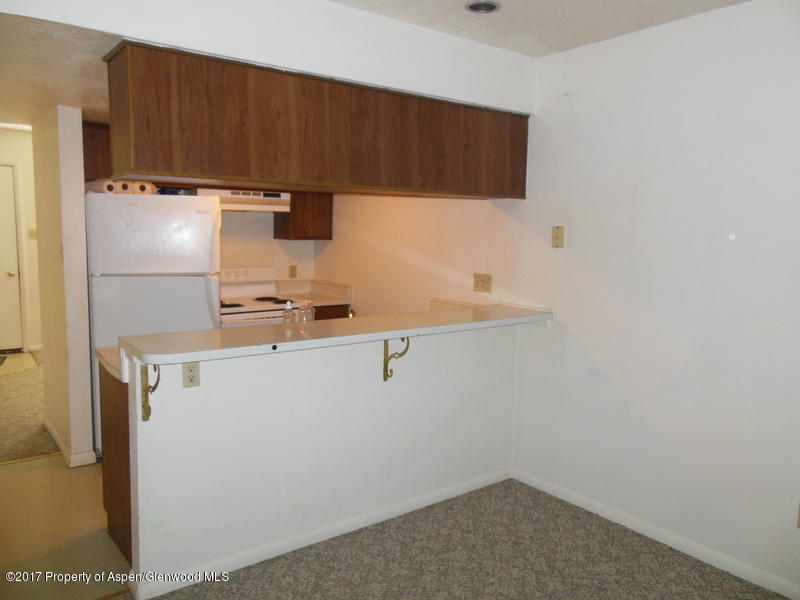 1393 West 2nd Street Craig, CO 81625 - Photo 14 of 16 a kitchen with a refrigerator and cabinets