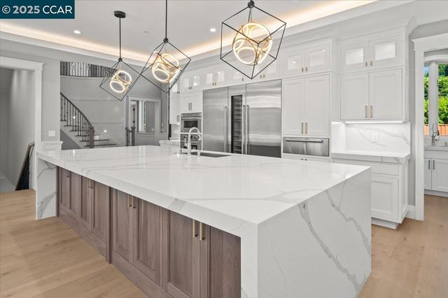 a kitchen with granite countertop white cabinets and a large window