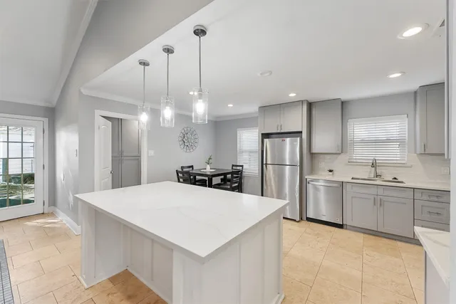 a large kitchen with kitchen island a sink stainless steel appliances and cabinets