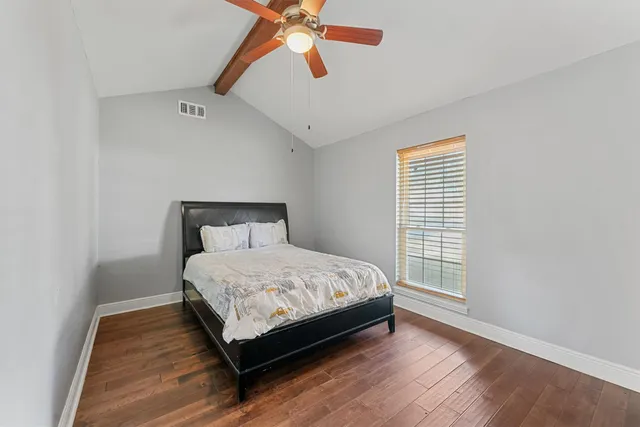 a bed sitting in a bedroom next to a window