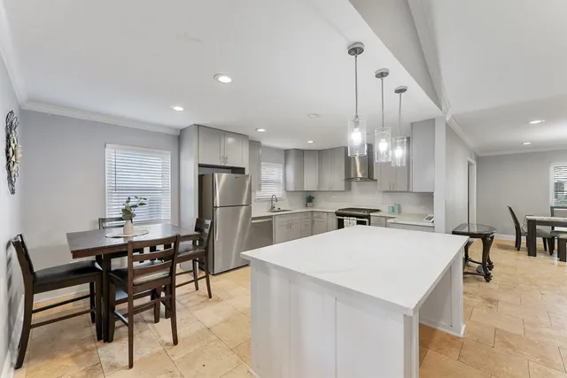 a kitchen with a dining table chairs refrigerator and cabinets