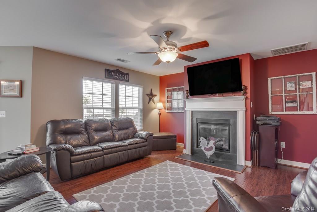 4411 Kiddle Lane Monroe, NC 28110 - Photo 12 of 24 a living room with furniture a fireplace and a flat screen tv