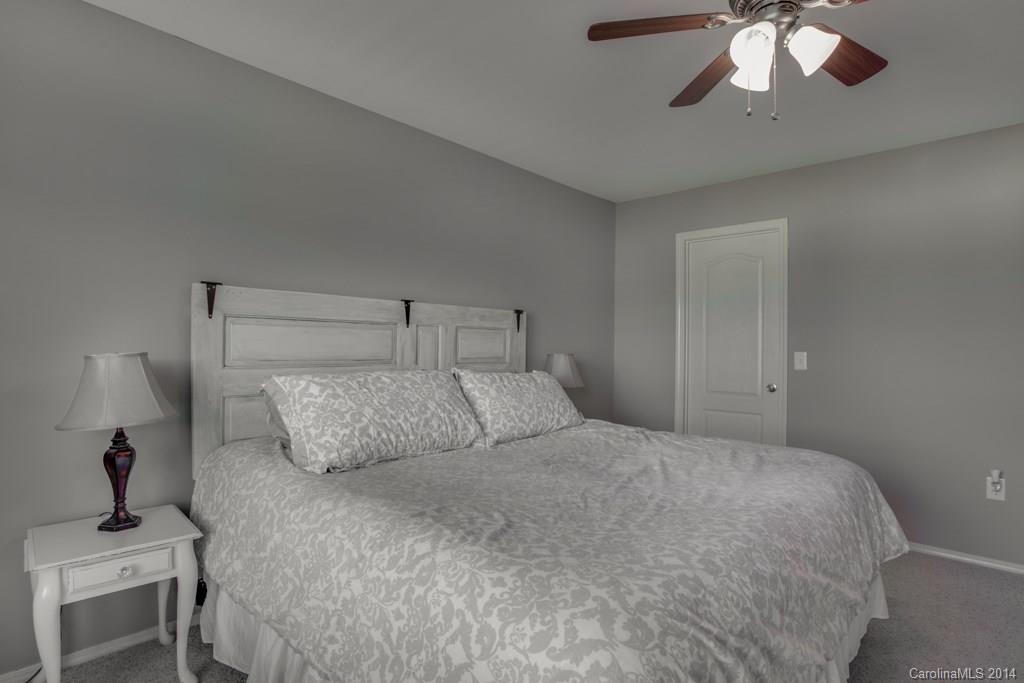 4411 Kiddle Lane Monroe, NC 28110 - Photo 21 of 24 a bedroom with a large bed and a chandelier