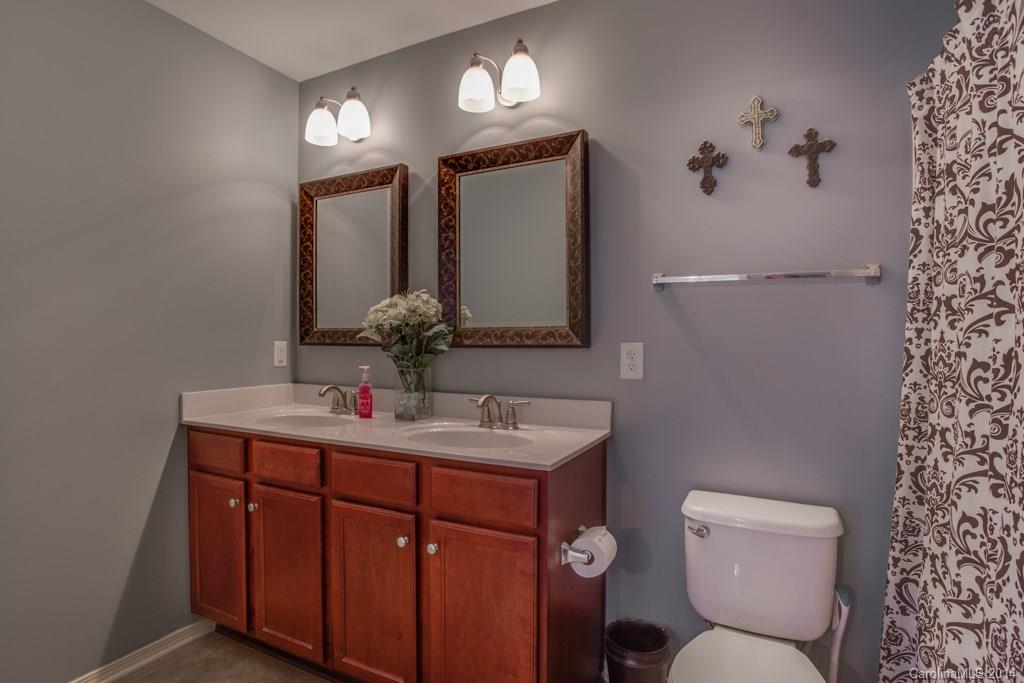 4411 Kiddle Lane Monroe, NC 28110 - Photo 22 of 24 a bathroom with a toilet sink and mirror