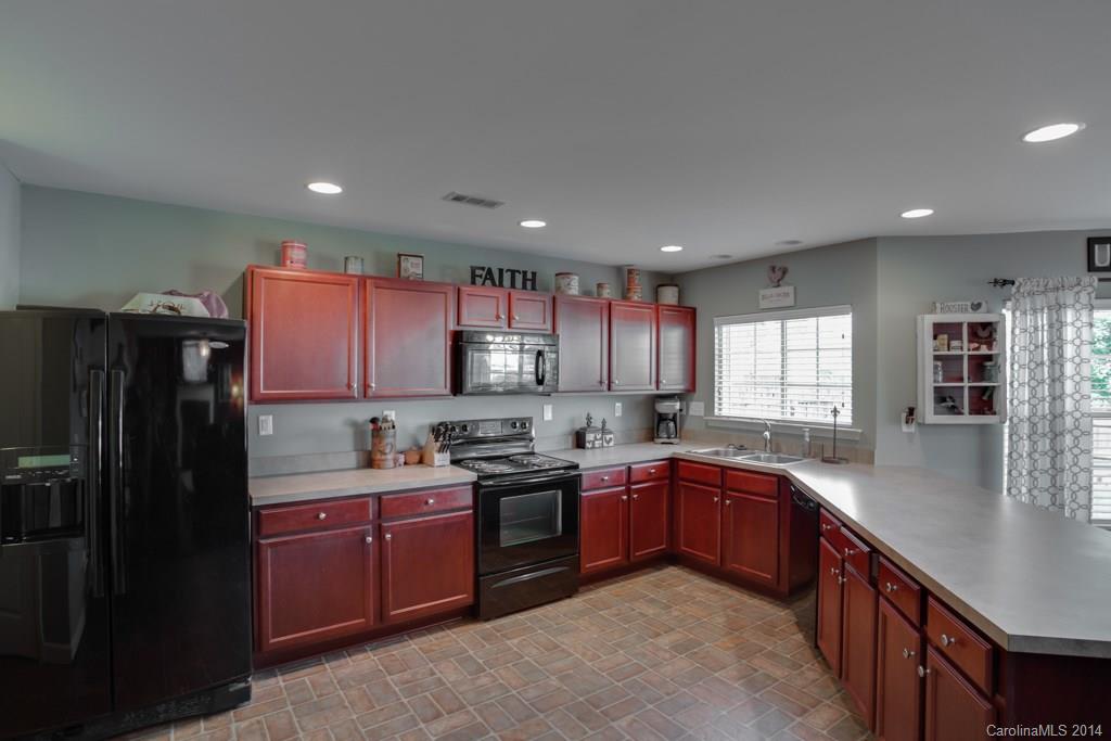 4411 Kiddle Lane Monroe, NC 28110 - Photo 6 of 24 a kitchen with stainless steel appliances granite countertop a sink stove refrigerator and cabinets
