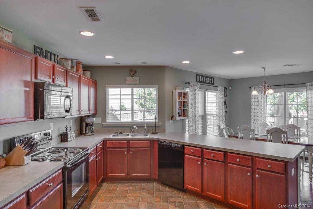 4411 Kiddle Lane Monroe, NC 28110 - Photo 7 of 24 a large kitchen with stainless steel appliances granite countertop a sink stove and cabinets