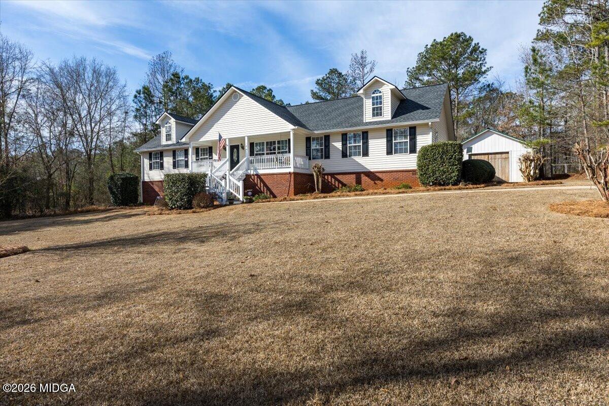 a front view of a residential houses with yard and trees