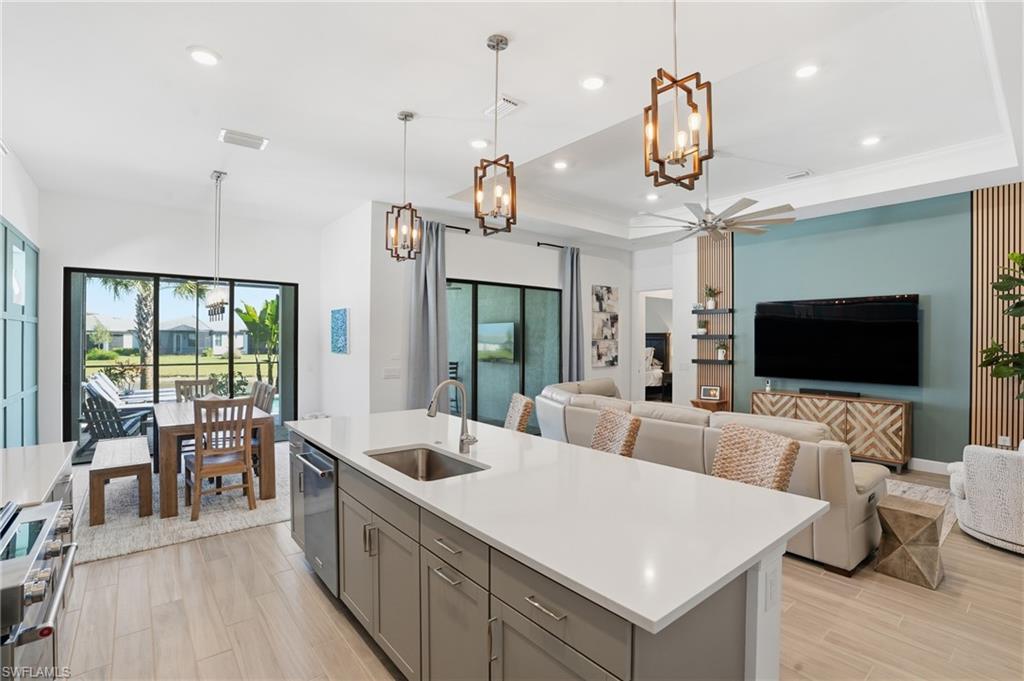 a large living room with stainless steel appliances kitchen island granite countertop furniture and a flat screen tv