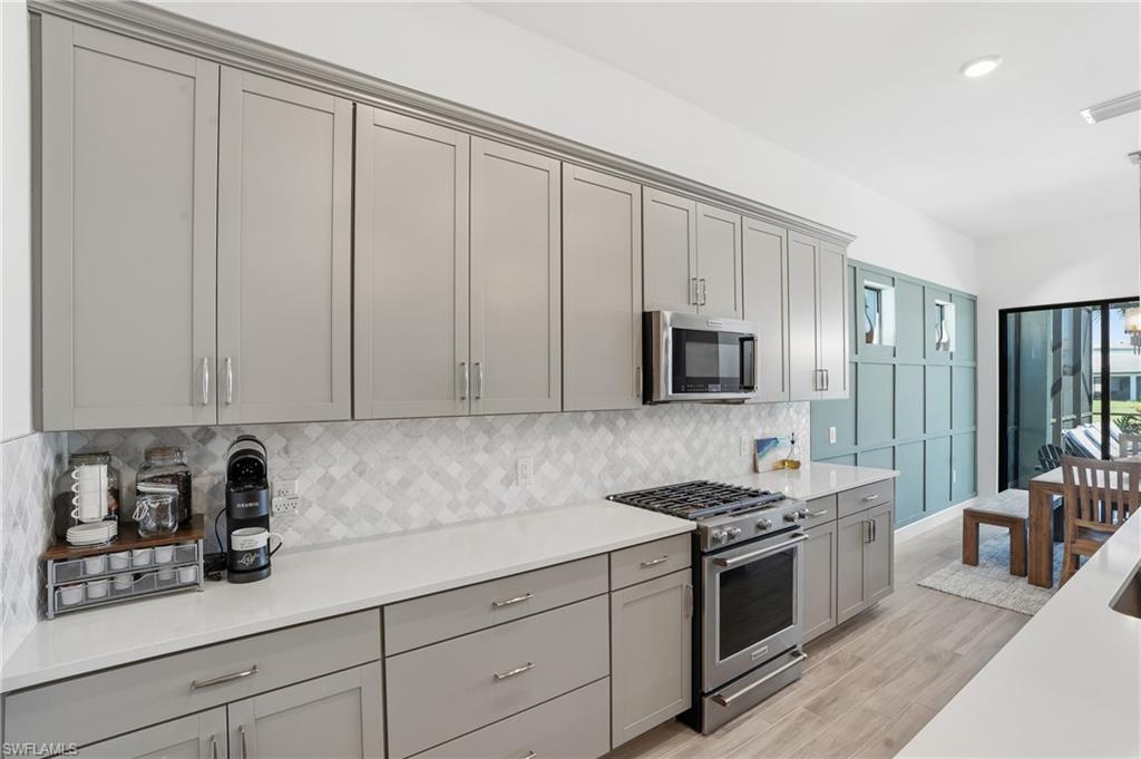 1872 Terreno Boulevard Naples, FL 34120 - Photo 13 of 50 a kitchen with granite countertop white cabinets and stainless steel appliances