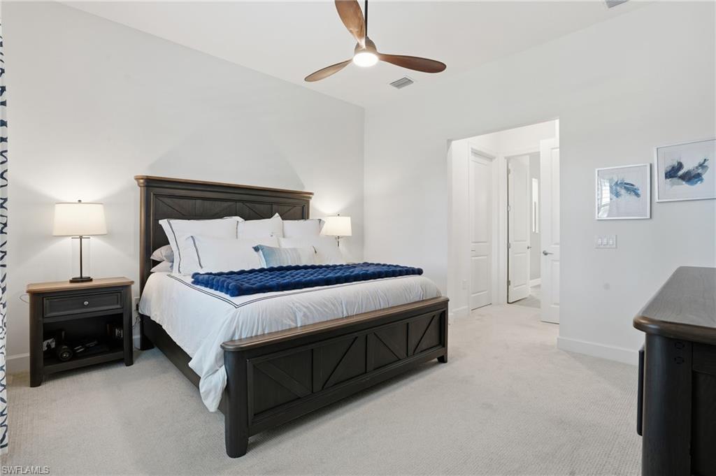 1872 Terreno Boulevard Naples, FL 34120 - Photo 20 of 50 a bedroom with a bed and a lamp