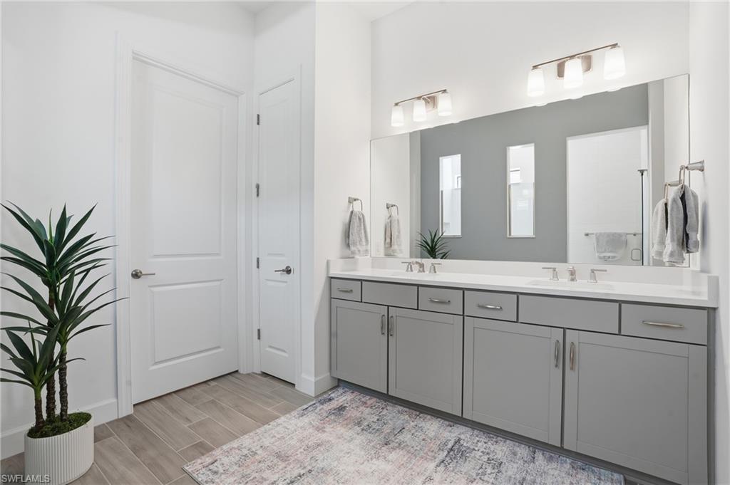 1872 Terreno Boulevard Naples, FL 34120 - Photo 21 of 50 a spacious bathroom with a granite countertop sink a mirror and a shower