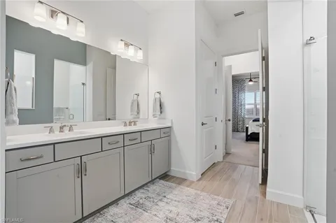 a spacious bathroom with a double vanity sink and mirror