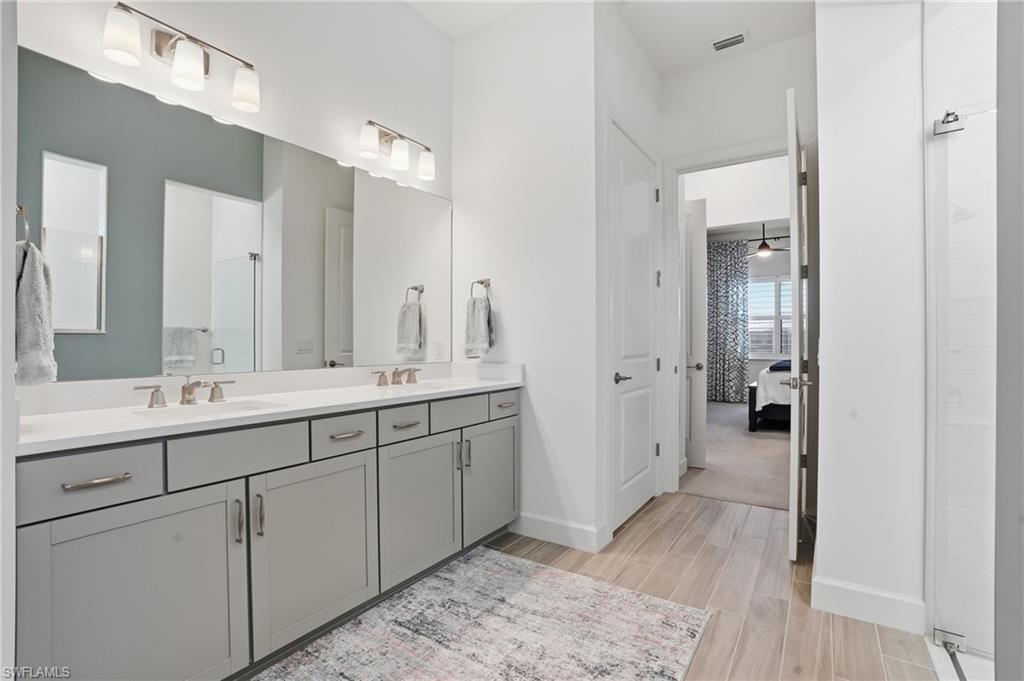 1872 Terreno Boulevard Naples, FL 34120 - Photo 23 of 50 a spacious bathroom with a double vanity sink and mirror