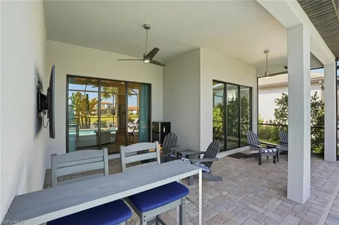 a living room with furniture tv and large windows