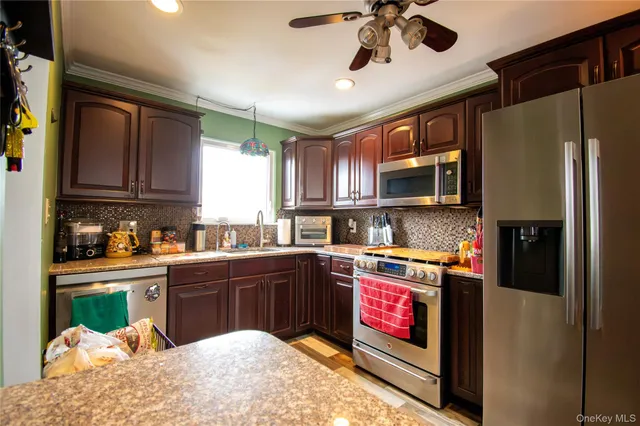 a kitchen with stainless steel appliances granite countertop a refrigerator a stove top oven a sink and dishwasher
