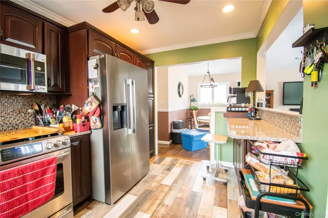 a kitchen with stainless steel appliances kitchen island granite countertop a refrigerator and a stove