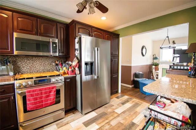 a kitchen with stainless steel appliances granite countertop a refrigerator stove and sink