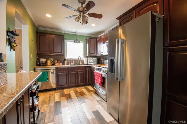 a kitchen with a refrigerator a sink and dishwasher with wooden floor
