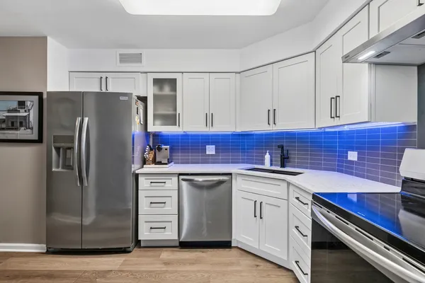 a kitchen with stainless steel appliances granite countertop a refrigerator stove and sink