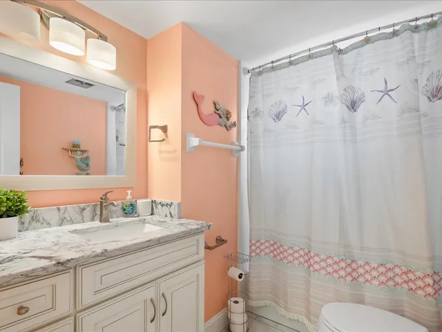 a bathroom with a granite countertop sink toilet and shower