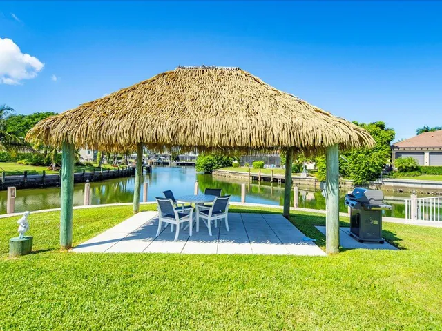 a view of a chairs and table in the patio with a lake view