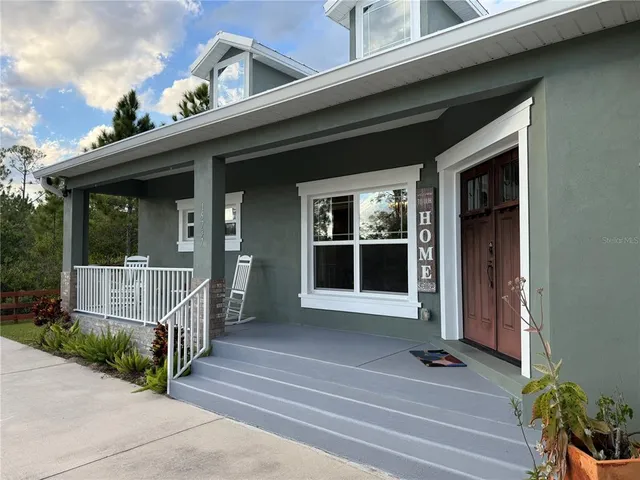 a view of a house with a large window and wooden fence