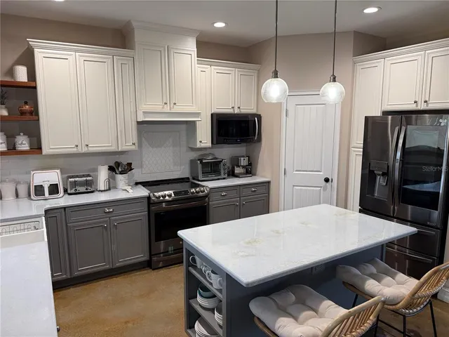 a kitchen with a stove a refrigerator and a dining table